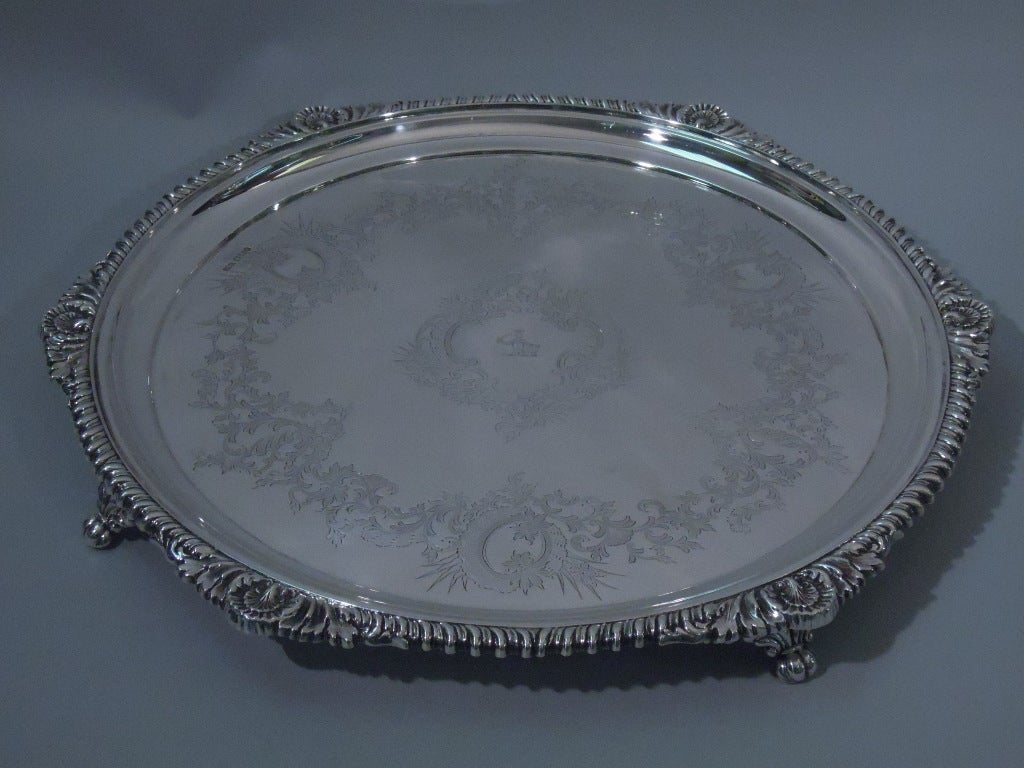 Victorian sterling silver salver. Made by Atkin Brothers in Sheffield, England in 1897. Circular with curved sides. Well has etched foliage and central asymmetrical cartouche with engraved sword-bearing knight. Rim is everted with gadrooning,