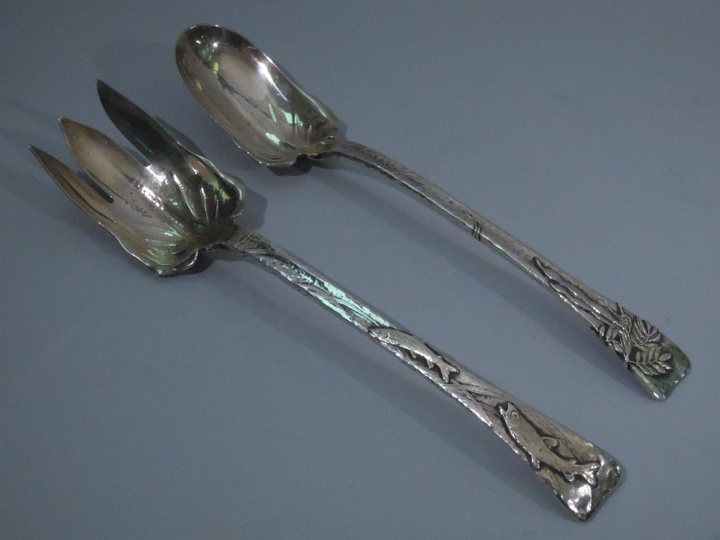 Sterling silver long-handled salad serving set in Lap Over Edge pattern. Made by Tiffany, ca. 1885. This pair comprises 1 fork and 1 spoon. Both pieces have allover hammering, a tapering handle, and applied ornament (fish and foliage on fork,