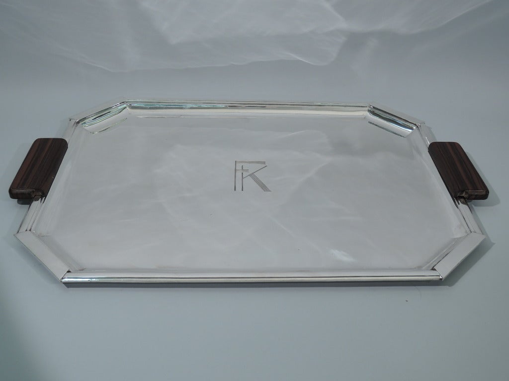 Art Deco 950 silver serving tray. Made by Henri Laparra in Paris, ca. 1925. Rectangular with chamfered corners. Side handles are silver with stained-wood mounts. Geometric monogram engraved in center. A striking period piece – for use and display.