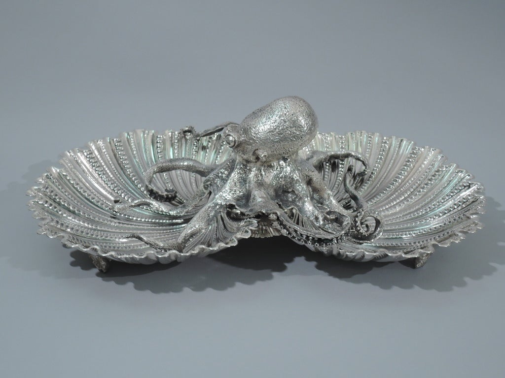 Sterling silver seafood double-bowl. Made by Buccellati in Italy. Two joined scallop-shell bowls rest on 6 scallop-shell supports. A traditional form dramatically updated by the figure of an octopus squatting in the center, its curled and tangled