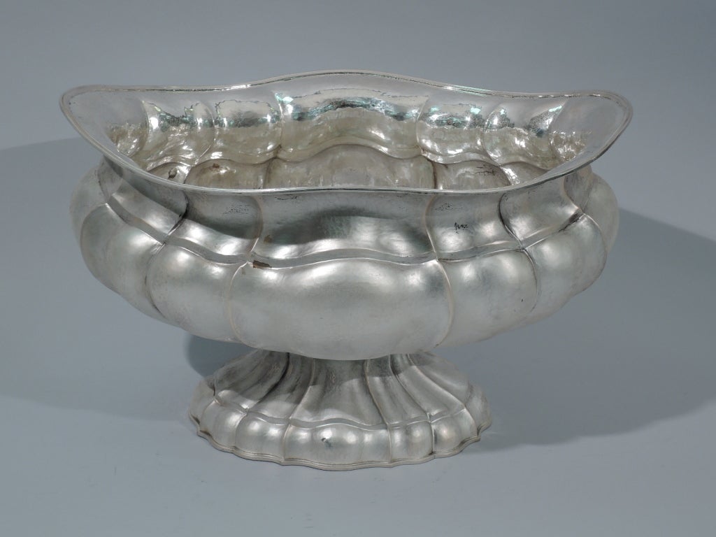 Hand-hammered 800 silver centerpiece bowl made by Bruno Vitali in Padua, Italy, c1980. Squat, ovoid and lobed bowl rests on ovoid and lobed dome foot. Reeded and asymmetrical rim. Molded foot rim. Hallmark includes phrase 