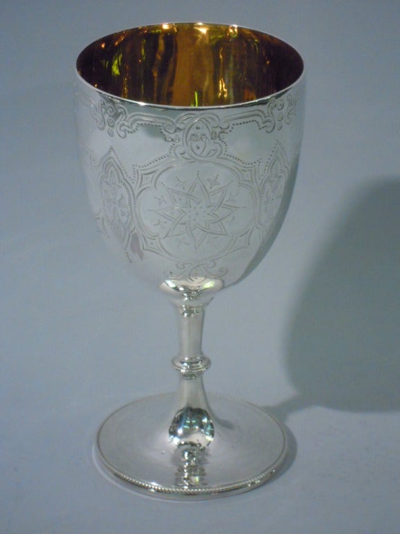 Victorian sterling silver goblet made by Robert Harper in London in 1864. Tapering bowl, knopped stem and raised circular foot. Quatrefoil cartouches with strapwork engraved on bowl. Some inset with stars and flowers. Two are blank for engraving.