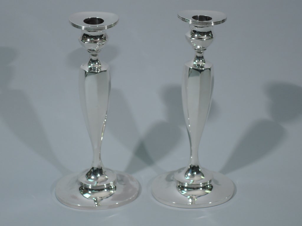 Pair of sterling silver candlesticks. Made for Tiffany in New York. Ovoid and faceted shaft on reeded oval foot mounted to oval base. Socket is also faceted with oval and reeded detachable bobeche. Weighted. Hallmark includes phrase “Made for