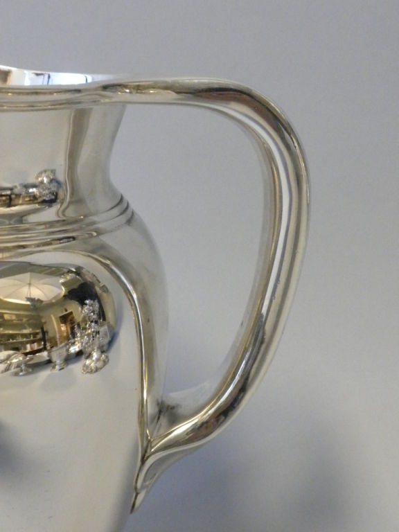 This beautiful sterling silver water pitcher was made by Tiffany & Co., New York, in 1907.  It is fully hallmarked on the base with Tiffany & Co.’s maker’s mark, pattern #16974, order number, makers and sterling standard mark.  The pitcher is of