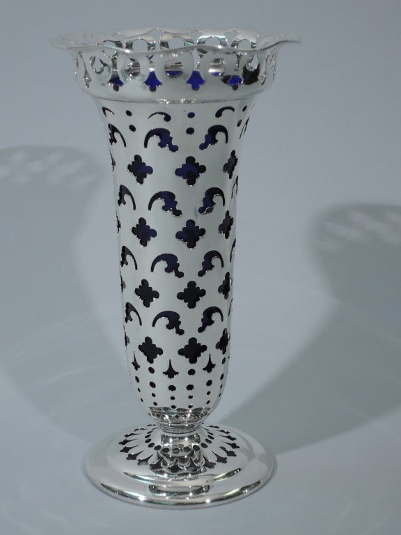 Sterling silver pierced vase with cobalt glass liner. Made by Tiffany in New York, ca. 1902. Tapering sides with curved, flared and scrolled rim, and raised foot. Symmetrical pierced geometric ornament. Liner has straight and tapering sides. The