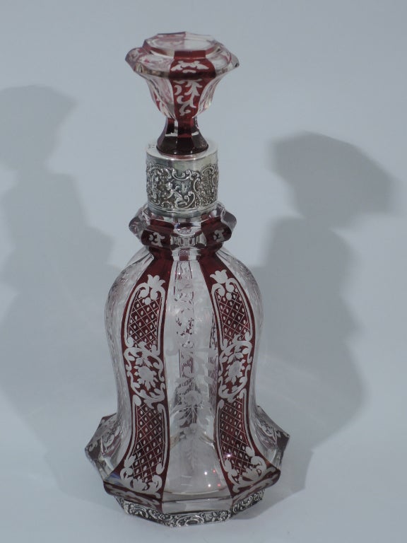 Bohemian glass decanter with 800 silver mounts, ca. 1900. Faceted and baluster body with flared base and faceted foot. Cylindrical neck mounted to faceted knop. Stopper is faceted and concave with short plug. Decanter and stopper have alternating