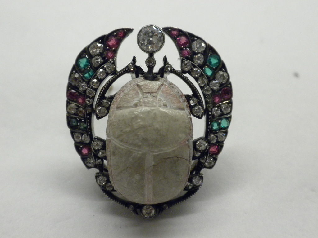 Beautiful Antique Faience Scarab, Diamond, Ruby and Emerald, Silver topped Gold Mounted Brooch, Circa 1860. The faience scarab with cushion-shaped emerald and ruby wings, old European-cut diamond accents, Diamonds total approximately 1.85 carats,