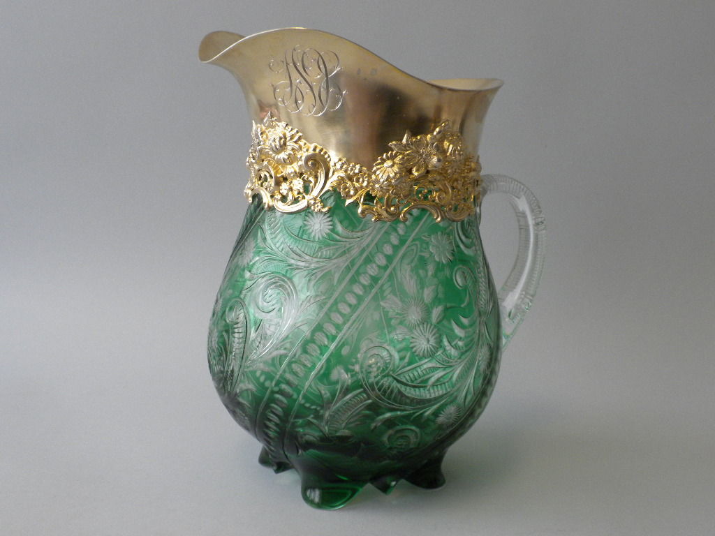 This beautiful Green to Clear Cut Crystal Pitcher with an ornate Sterling Silver Gilt Mount, from the American Brilliant Cut Glass Period, was made by Redlich Co., New York and retailed by Bailey Banks and Biddle, Philadelphia, PA, circa 1900.  The