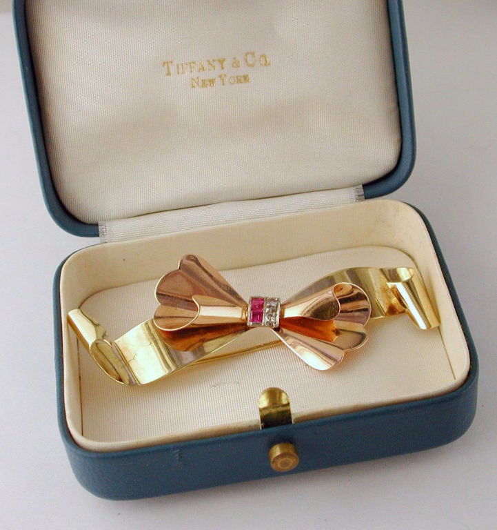 14kt yellow and pink gold bow pin accented with small rubies and diamonds.