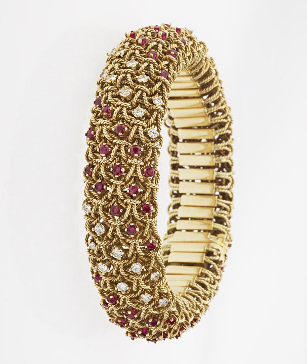 This visually stunning and masterfully made 18 karat yellow gold twisted wire bracelet  is set with lively rubies and approximately 2.0 carats of diamonds.  Stamped 