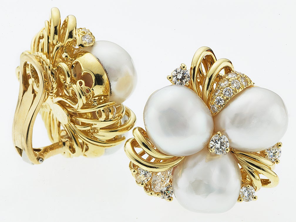 Pair of ladies cluster style clip earrings, in 18 karat yellow gold, set with 6 natural baroque South Sea Pearls and 34 round colorless, flawless diamonds (2.22 ct t.w.) .  Signed Henry Dunay
