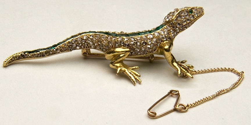 This very beautiful Edwardian lizard pin is attributed to Maison Plisson & Hartz, a partnership which existed from 1889 to 1904 in Paris.  The body is set with diamonds and a bright green line of emeralds set in 18 karat yellow gold.  The pin
