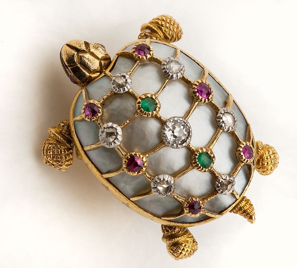 A lovely 18 karat yellow gold Turtle Pin featuring a mother of pearl shell highlighted with small diamonds, rubies and demantoid garnets. Superb surface detail throughout - the head and legs are articulated. (Note: The pin closure is a replacement