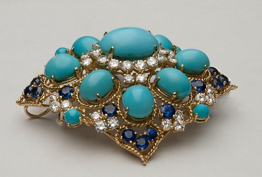 This magnificent brooch reflects the importance of the Indian and Middle Eastern influences on jewelry design of the late 60s and early 70s.  It features 13 superb Persian turquoise stones: (1) 13.20 ct., (8) 4.31 - 4.77 ct. each and (4) .035 ct.