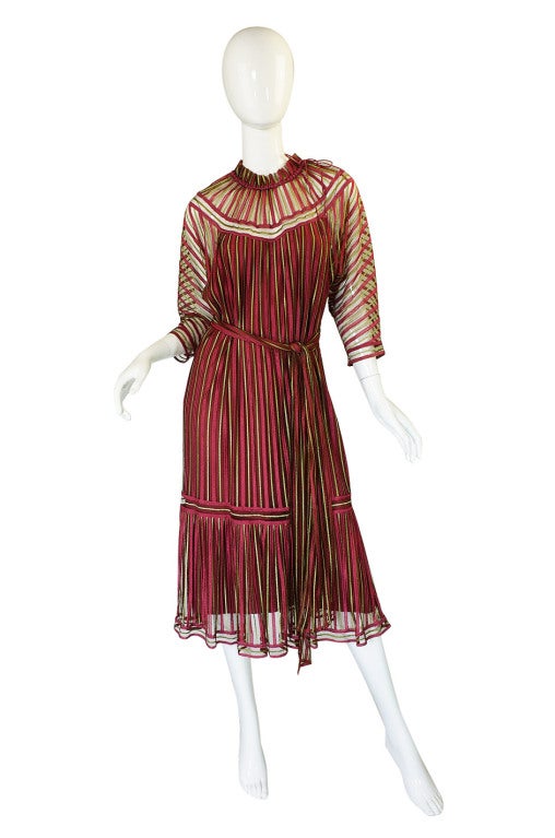 This is an unusual and wonderful Janice Wainwright dress! The outer shell of the dress is entirely done on fine silk netting upon which has been applied pinky salmon and pale yellow-green colored strips of a woven ribbon. Under this exterior is a