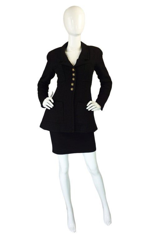 A stupendous Chanel in a not so basic black! A textured black boucle is set off to perfection with black & gold buttons - all with that classic CC logo of course! Six gorgeous Chanel logo buttons finish the front and more are at the back of the