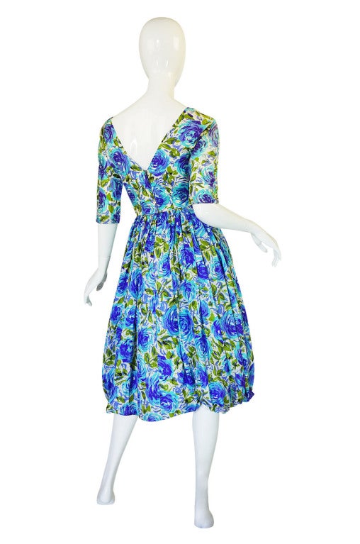 Absolutely gorgeous and romantic 1950s dress with superb detailing! The silk that it is made of is itself amazing - it is that light weight silk twill that is comparable to a fine scarf in feel. The colors that have then been screened onto this