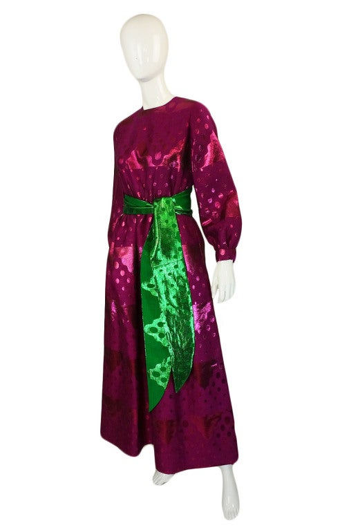 A stunning sixties full length dress by Oscar De La Renta that has been constructed from a beautiful silk brocade that has a base matte finish with a metallic thread woven through it to create the designs. The metallic thread is in the same hue as