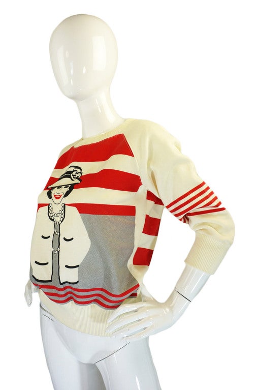 How can you not smile when you see this? An amazing authentic Chanel sweatshirt with a fantastic Coco Chanel motif heat applied and with her grinning from ear to ear! With the recent trend towards tops and piece with bold graphics and prints this