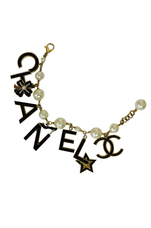 Wonderful Chanel logo charm bracelet. Comprised of opaque glass pearl beads with seven charms forming the infamous Chanel name! I love the little touches - a pearl accented clover sits on the H, a chic little shoe tops the N and a star highlights