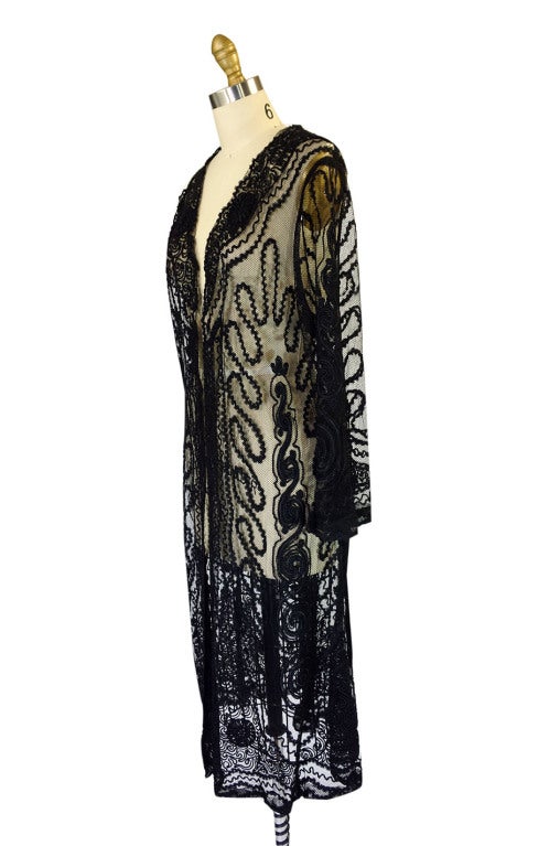 An amazing statement piece in black net with the most amazing three dimensional embroidery and cord work covering the entire thing. Beautiful long vertical panels of applique covers the piece from shoulder to hem. I love the extra detailing that