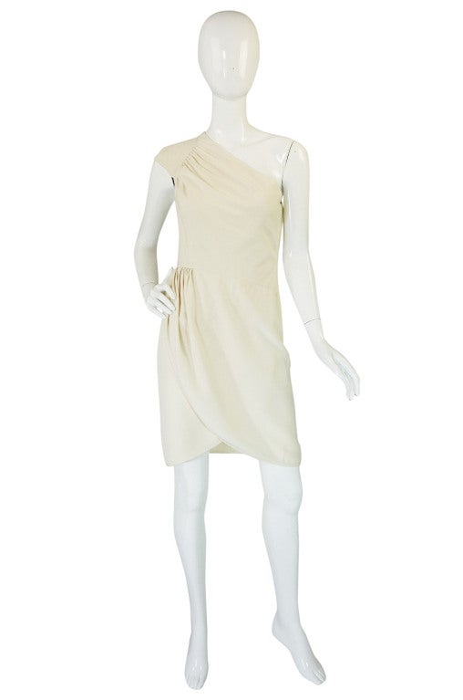 Amazing off white one shoulder cocktail dress by Valentino! The bodice swoops across the bust with an slight gathered inset into the shoulder detail. It gives the effect of the wearer being wrapped and adds a nice refined extra touch to the bodice.