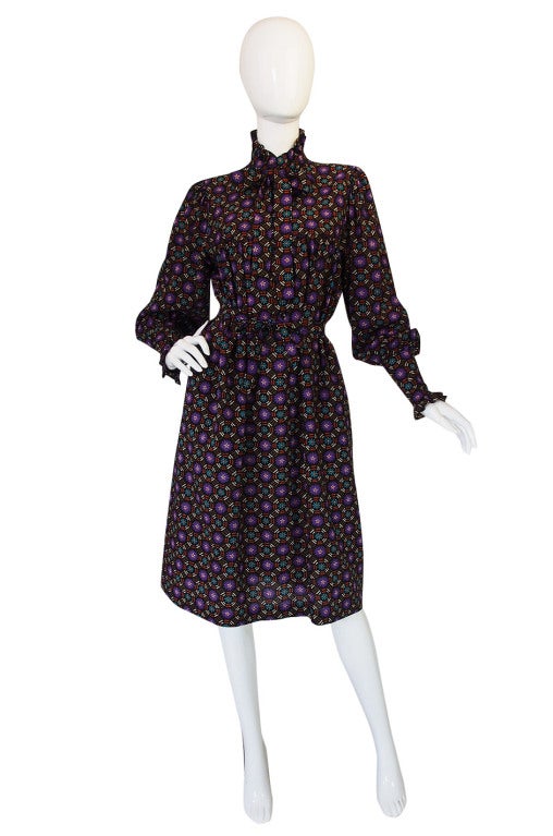 This is a classic YSL silhouette. A high ruffled neck and attached tie sit atop a full smocked shape. The sleeves are tremendously full above a wide buttoned cuff. You can cinch it in as shown with the original tie belt or wear loose and full. The