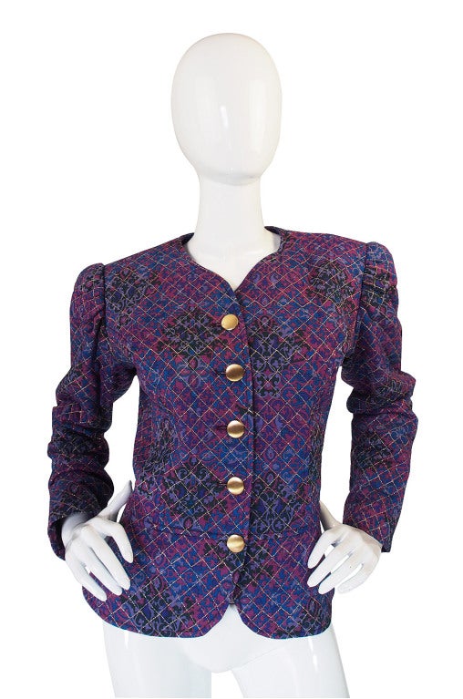 Purple print YSL jacket with quilted top stitch detailing. Flat gold toned buttons and signature wider upper arm. No flaws

Ships professionally dry cleaned

approx size 8-10

Shoulders: 16