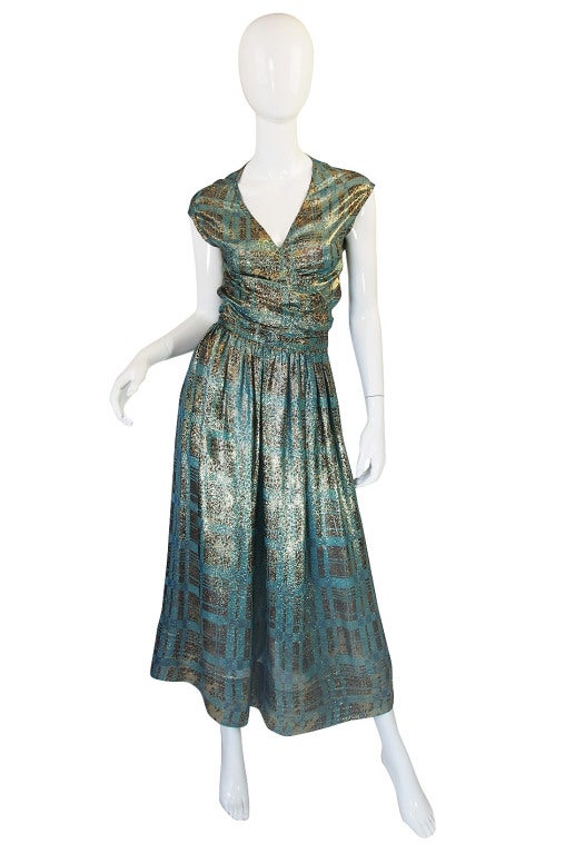 Feather light metallic silk chiffon is done in a combination of a stunning blue and gold. The checked parts have a subtle leopard feel print worked into them as well. I love the long skirt with its fullness and hidden side pockets. The top wraps and