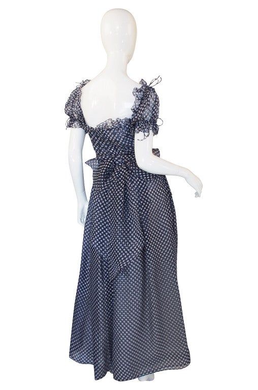 This is an incredible Nina Ricco Haute Boutique gown that would have been demi-couture, made to order on request. It is a silk organza that has a beautiful dot pattern. Typical of the seventies it is cut with a definitive nod tot he past and has a