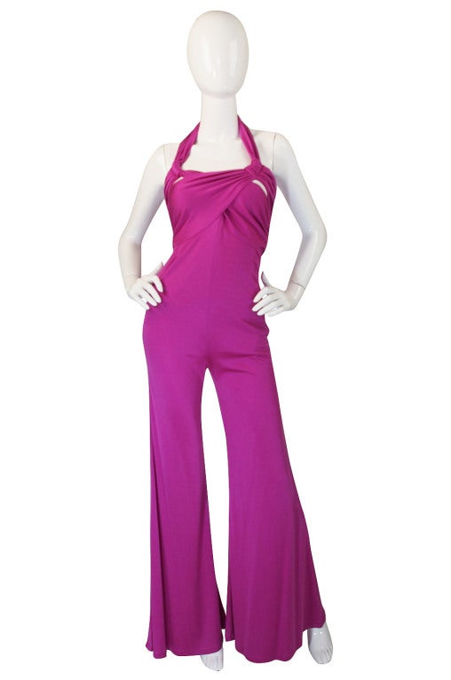 Sexy, fluid silk jersey dyed to a shocking, vivid pink are the foundation of this amazing jumpsuit by Valentino. The fabric is slinky and sensual and the cut divine. Wide fluid legs add supermodel height. The halter top twist and wraps around the
