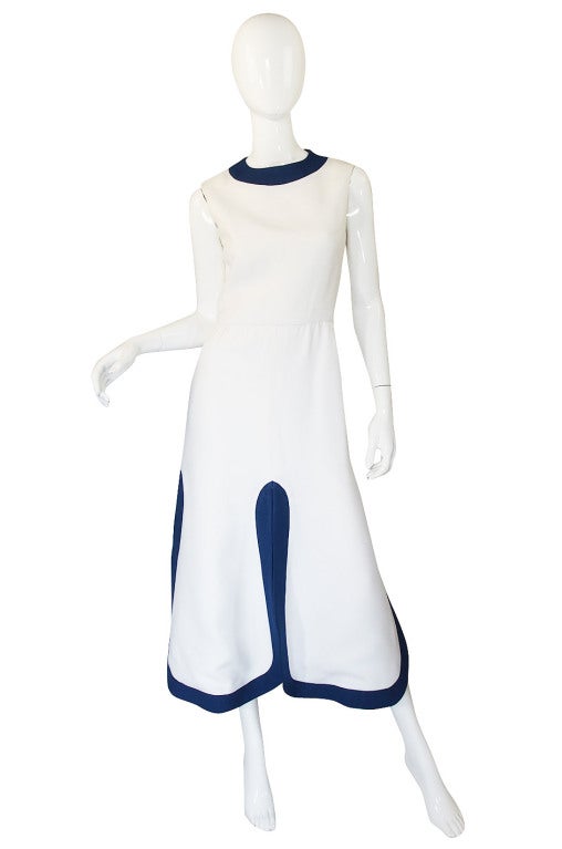 Superb white linen like fabric is cut and shaped into one of the most classic Cardin designs! The bodice is cut simply with no sleeves and a rounded neck accented by the panel of blue. The waist curves in just a touch and then the skirt skims over