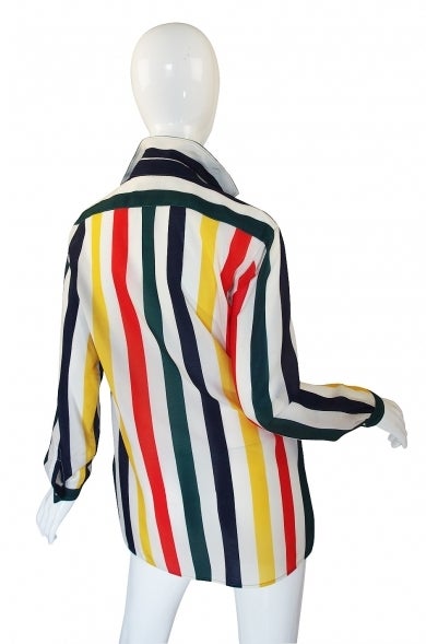 This fabulous striped silk top from Christian Dior is extra special as we found documentation of its exact date! It is shown here in action from a 1977 edition of L'officiel! A high grade silk has brilliant stripes of color running down it in navy,