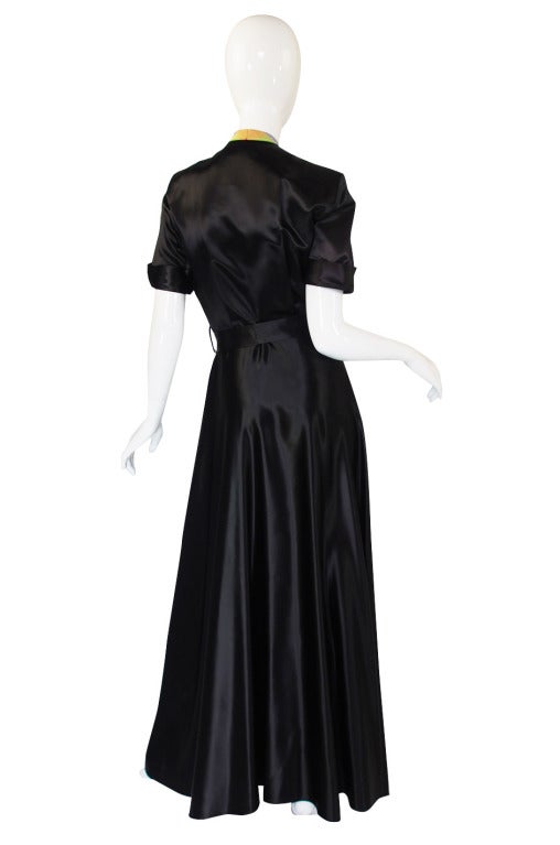 This is a spectacular late 1930s, early 1940s Hostess gown and it strikingly similar to the one we have added to the photos. That photo was taken in 1939 when these were the height of fashion! The body of the gown is a mix of a black slipper satin