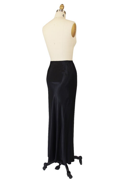 This is drop dead sexy! A to the floor silk satin skirt is cut on the bias and has the highest slit running up one leg! It is almost indecent between the length of leg exposed and the slinkiness of that fluid fabric. Its a signature piece and can be