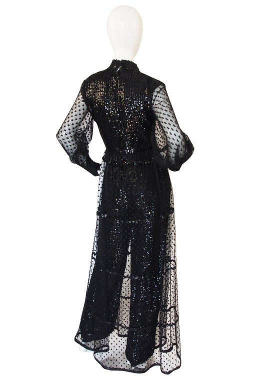 This is am amazing piece and similar to another I have had in the past! At first glance it appears to be a gown but at closer inspection you see that it is a skirted jumpsuit! The attached skirt that sits over the interior jumpsuit is made of a net