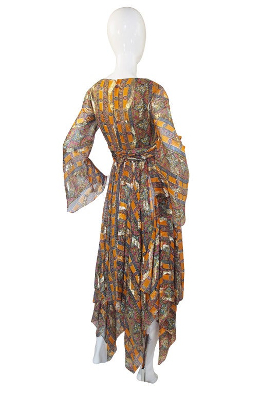 A stunning, early 1970s Bill Blass gown that has a unique and beautiful design! That flowing bohemian feel skirt is created by huge 