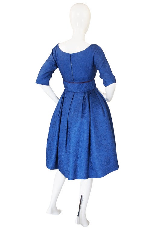 This is an incredible reference numbered Christian Dior from the 1950s. The color is a startling blue that is just divine! It is hand dyed on a textured silk brocade. The brocade has a raised pattern worked into it so depending on how the light hits