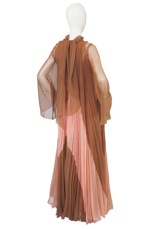 A very dramatic chiffon gown by the designer best known for dressing Marylin Monroe - Travilla! Done in an unusual pink and taupe combination the fabric has been perma pleated meaning that there is actually yards and yards of fabric in this! It
