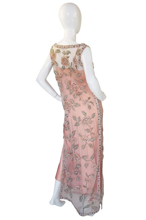 This is an exquisite 1960s net sheath whose exterior is covered with hand done bead work. Made of two layers of a fine pale pink net with flowers adoring its surface. You would rarely see this level of handwork on a piece today and if you did it