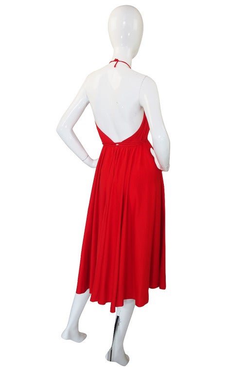 From the 1978 collection comes this amazing red Halston with its long attached ties that allow you to wrap and style the bodice, waist and hips in different ways to accentuate what and where you want. This is a shorter cocktail or day dress length
