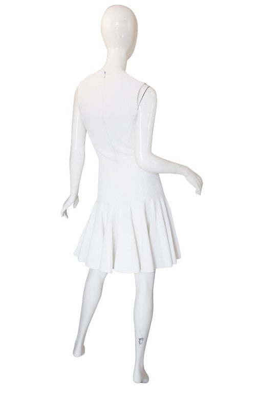 Quintessentially Alaia, this sexy pure white knit dress is instantly recognizable as one of his work. A stunning white stretch knitis used with different ribbing finishes used to created added depth and texture to the dress. The fit and flare shape