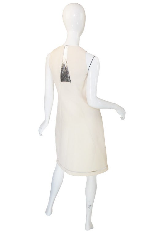 When you think about Rucci's work you think precision tailoring and cut. He is known to piece fabric together with the eye of the couturier and this chic little white dress with silver leather inserts is a good example of that. It has the feel of a