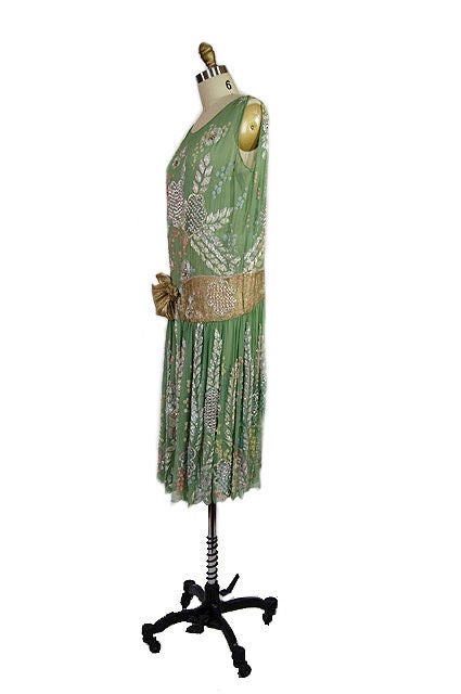 Exquisite 1920s dress in a remarkable and unusual shade of soft green. The silk chiffon is finished with mind boggling tiny stitches and a filigreed edge along the scalloped hem. The bead work is amazing. Entirely hand done and most remarkably - the
