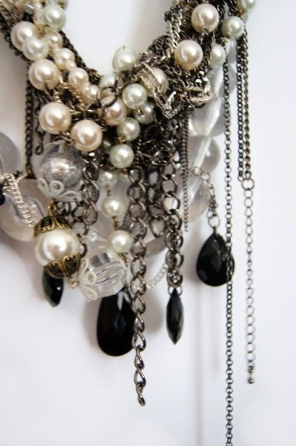 This ultimate statement bib neckpiece features multi layers of mixed tone mixed metal chains, two tone faux pearls, chunky clear faceted beads, Lucite beads and black oval resin beads. I adore the dripping bits of metal chain - its the perfect edgy,