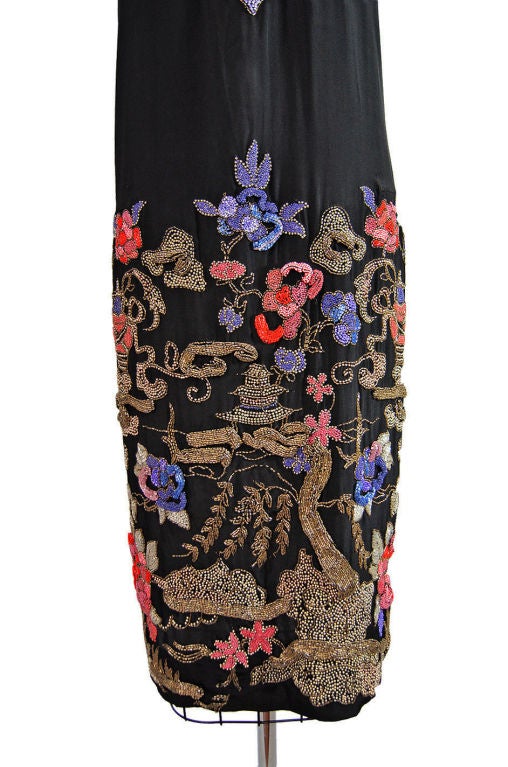 Exquisite 1920s piece has some of the most phenomenal bead work I have yet to see. The base of the dress is a heavy weighted silk in a matte black. It is in remarkable condition with no flaws. Onto this has been beaded a Asian influenced design