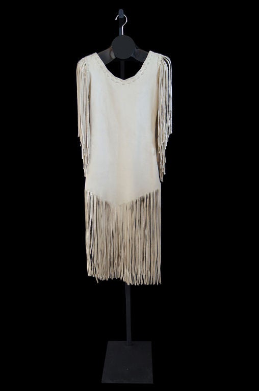 Insanely cool fringes deerskin original 1960s leather piece will make the most dramatic statement! Its hand made and whip-stitched and constructed form a ivory leather - smooth on the exterior and left raw on the interior. Its cut sheath style with