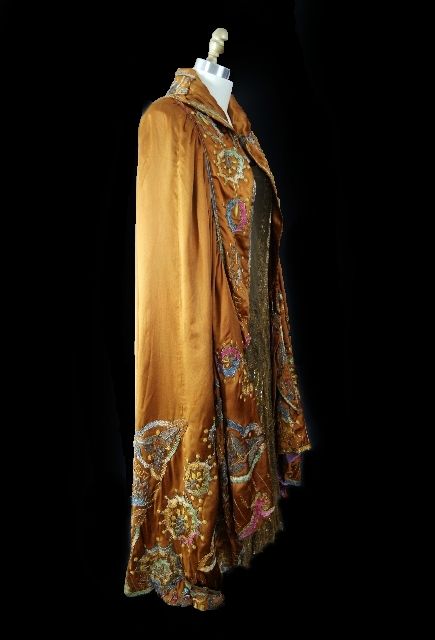 This cape is utterly amazing and a true work of art. Heavy, luxurious bronze silk drapes to perfection The collar, and the entire circumference of the cape is covered in stunning crewel work embroidery. The thread used is a hick embroidery thread in