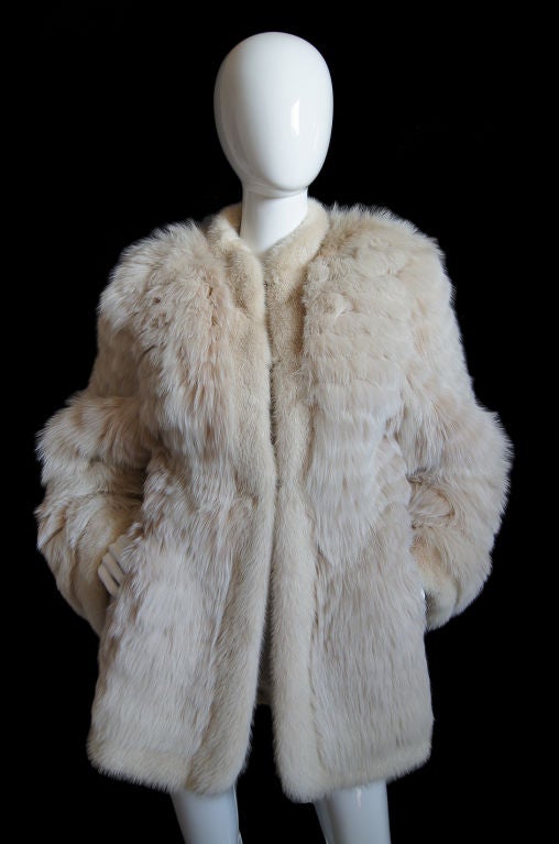 Fantastic Yves Saint Laurent Fox fur coat in an outstanding pale cream with white tipped fox. It has been made so it has a feathered appearance with the fur set in small rows. The cuffs and inside edge are a shorter haired fur - I believe it is