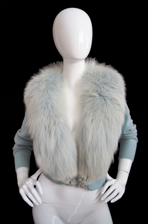 This is the ultimate Hollywood glamour girl vintage sweater! A soft baby blue cashmere is topped by a thick luxurious fox fur collar that is hand dyed to match the blue of the sweater! A jeweled clasp sits at the waist to close. The cut is cropped